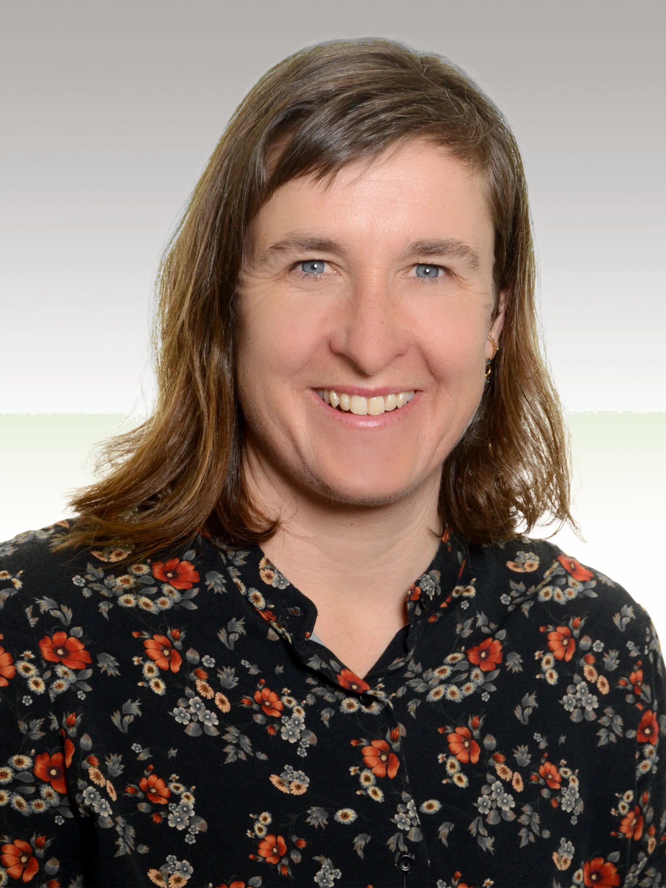 Claudia Borst lächelnd im Grünen.